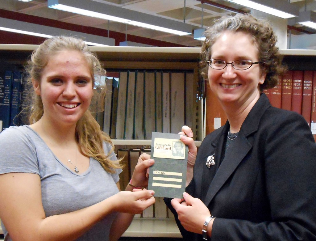 Alisa Mizikar, reference librarian, presents Audrey Feiler with a $100 book store gift card.